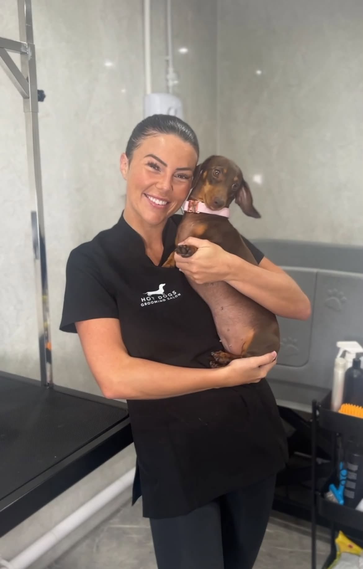 Lucy in the salon holding a smooth-haired dachshund